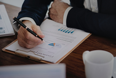 man at a desk working on a financial worksheet